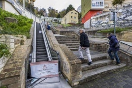 Dos hombres suben andando, ayer, por las escaleras del Río de la Pila al estar estropeadas las mecánicas.