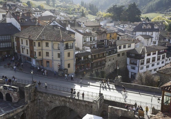 Calle principal de Potes y gente paseando por el puente.