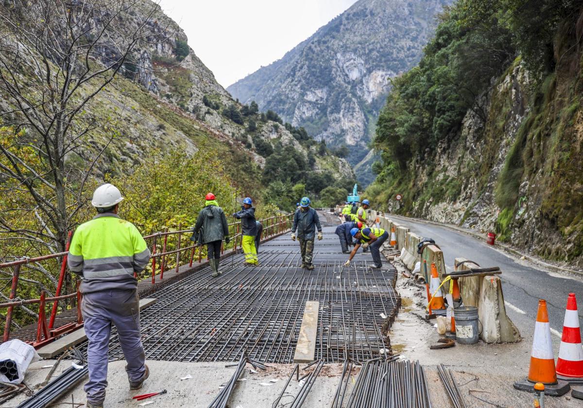 Obreros trabajan en la renovación de uno de los tramos con voladizo de la N-621, en el Desfiladero de la Hermida.