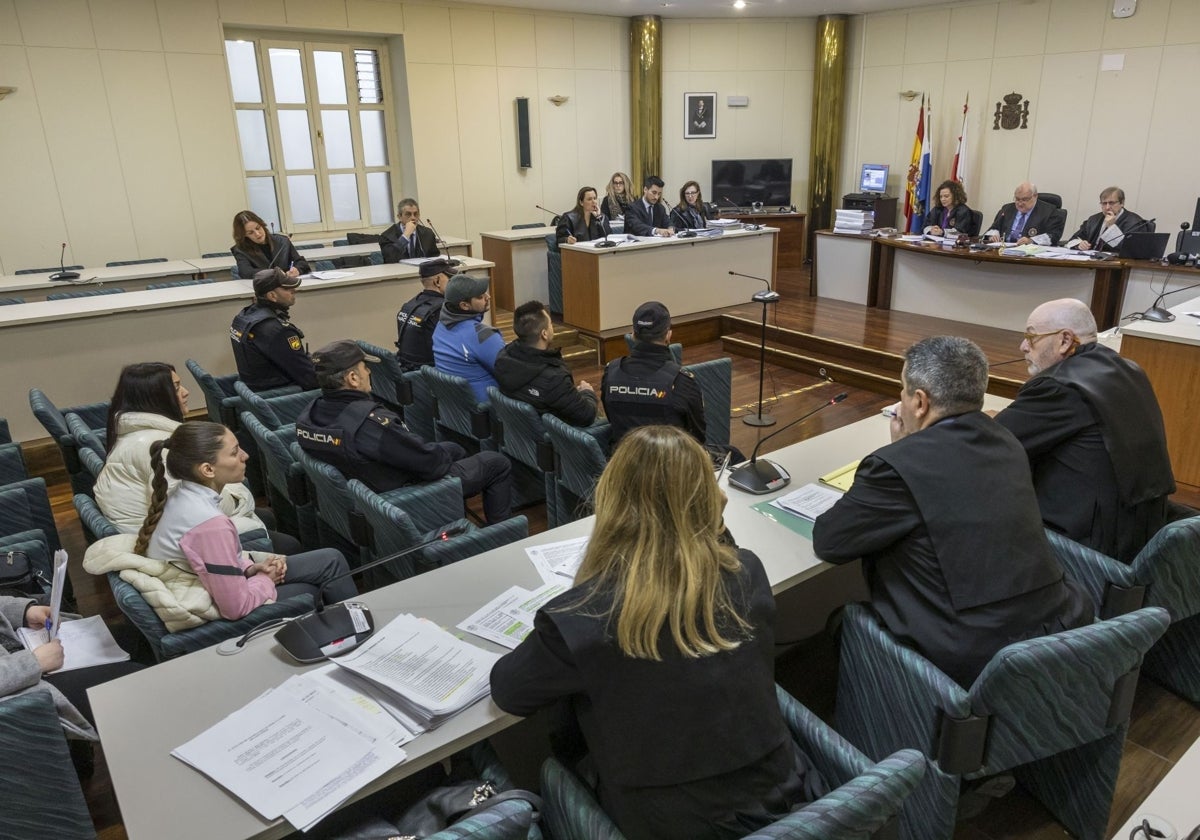 Los cuatro condenados, dos hombres (en primera fila), y dos mujeres (en tercera fila), durante el juicio celebrado este lunes en la Audiencia Provincial de Cantabria.