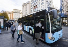 Usuarios del TUS suben al autobús en la parada de la plaza del Ayuntamiento de Santander.