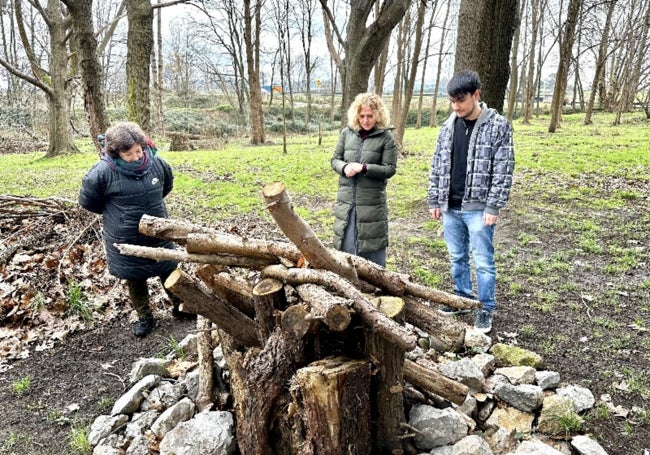 Los técnicos de Medio Ambiente del proyecto Torrelavega Conexión Natural, Alicia Polidura (izquierda) y Adrián Pérez (derecha), visitan una integración de madera muerta del Patatal donde se produjeron actos vandálicos, junto a la edil de Medio Ambiente, Patricia Portilla.