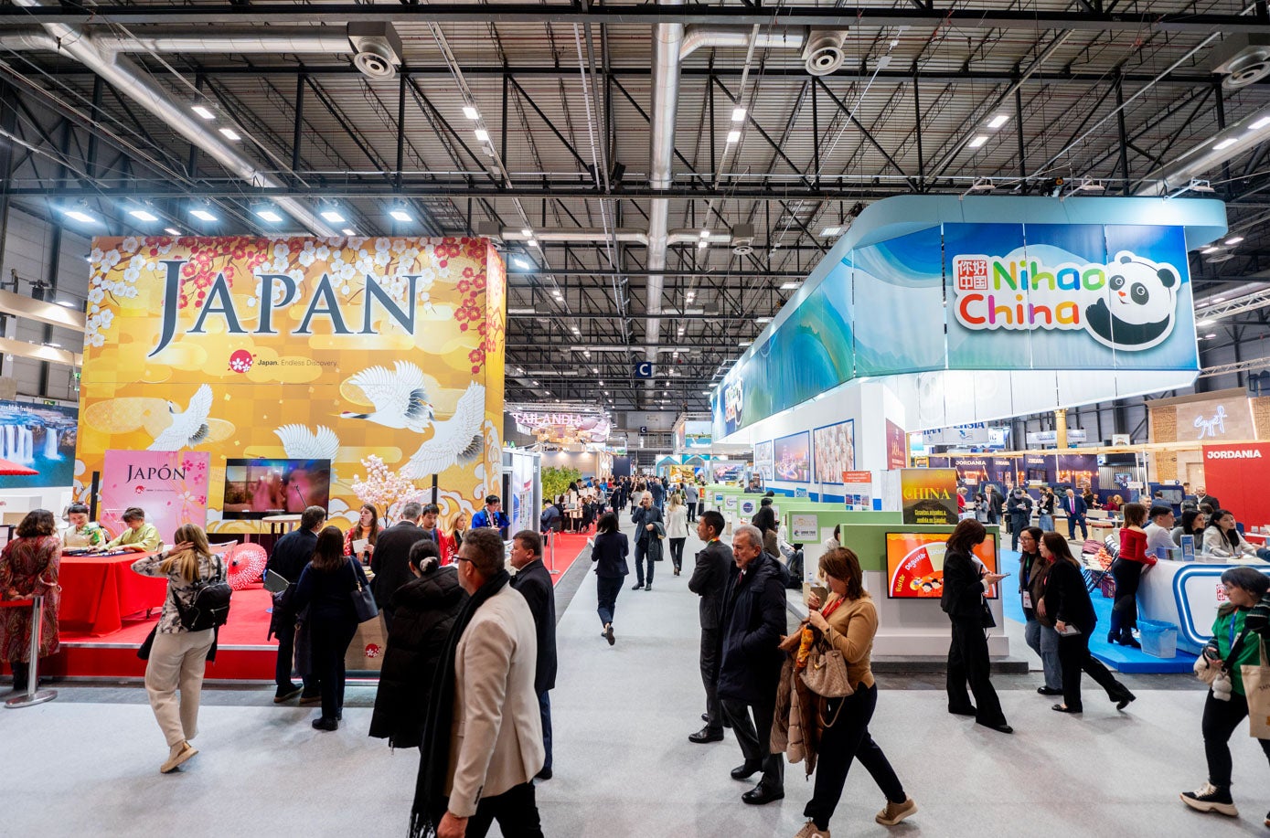 Visitantes ante carteles promocionales de Japón y China.