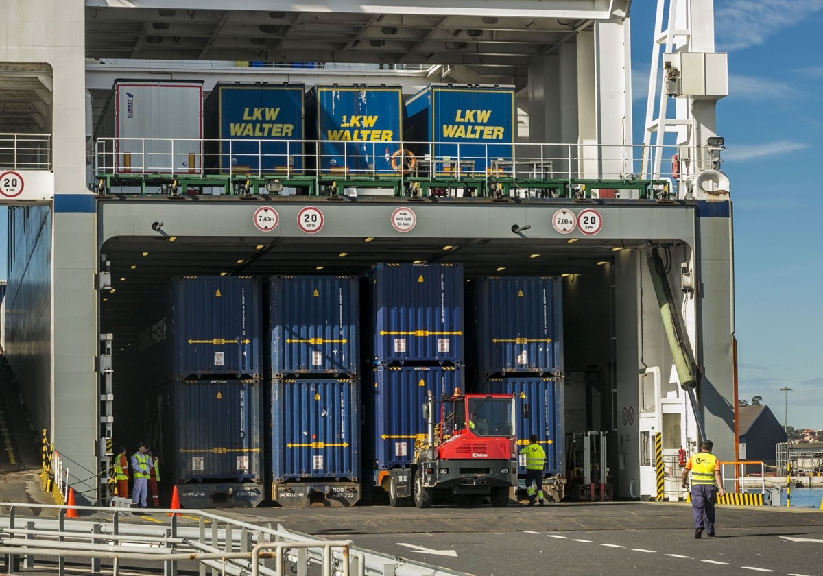 Operarios descargan contenedores de un barco en el Puerto de Santander.