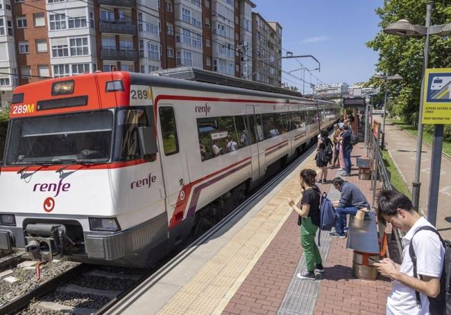 Los usuarios de las Cercanías esperan la llegada del tren en la estación de Muriedas.