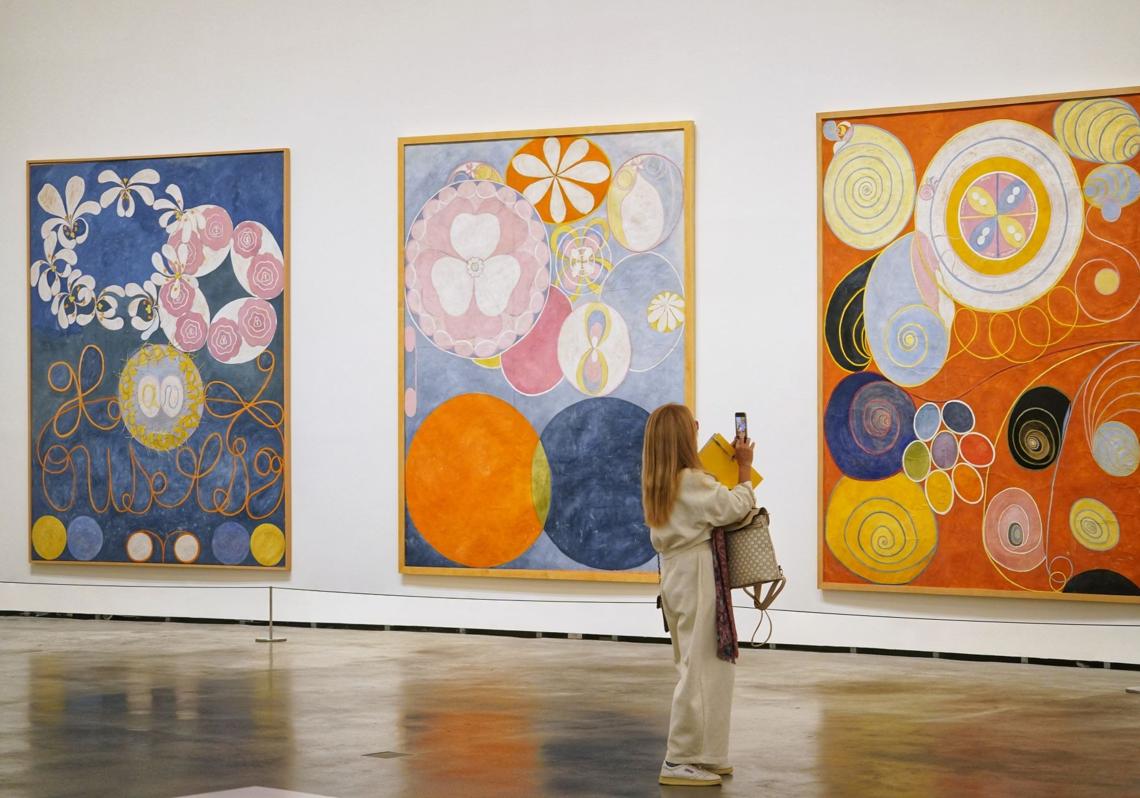 Una mujer fotografía uno de los cuadros de Hilma af Klint expuestos en el museo de Bilbao.