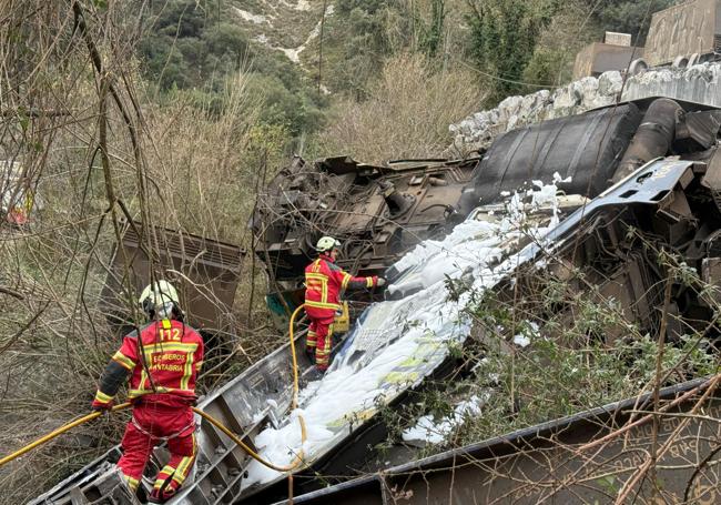 Los bomberos enfrían la zona tras el accidente.