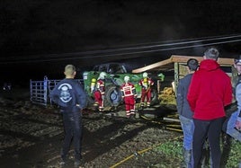 Los bomberos de Valdáliga, en el establo incendiado.