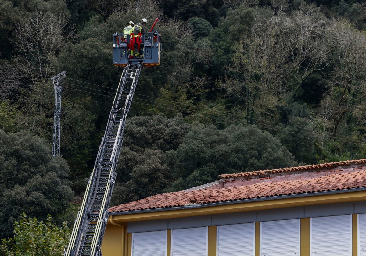 Bomberos trabajan en la techumbre afectada del colegio Valdáliga.