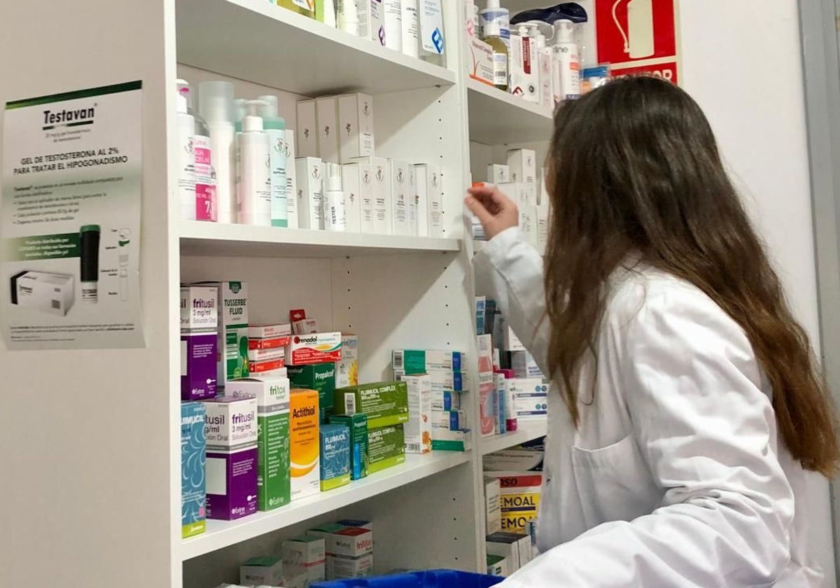 Personal de una farmacia de Cantabria repone los productos en una estantería.