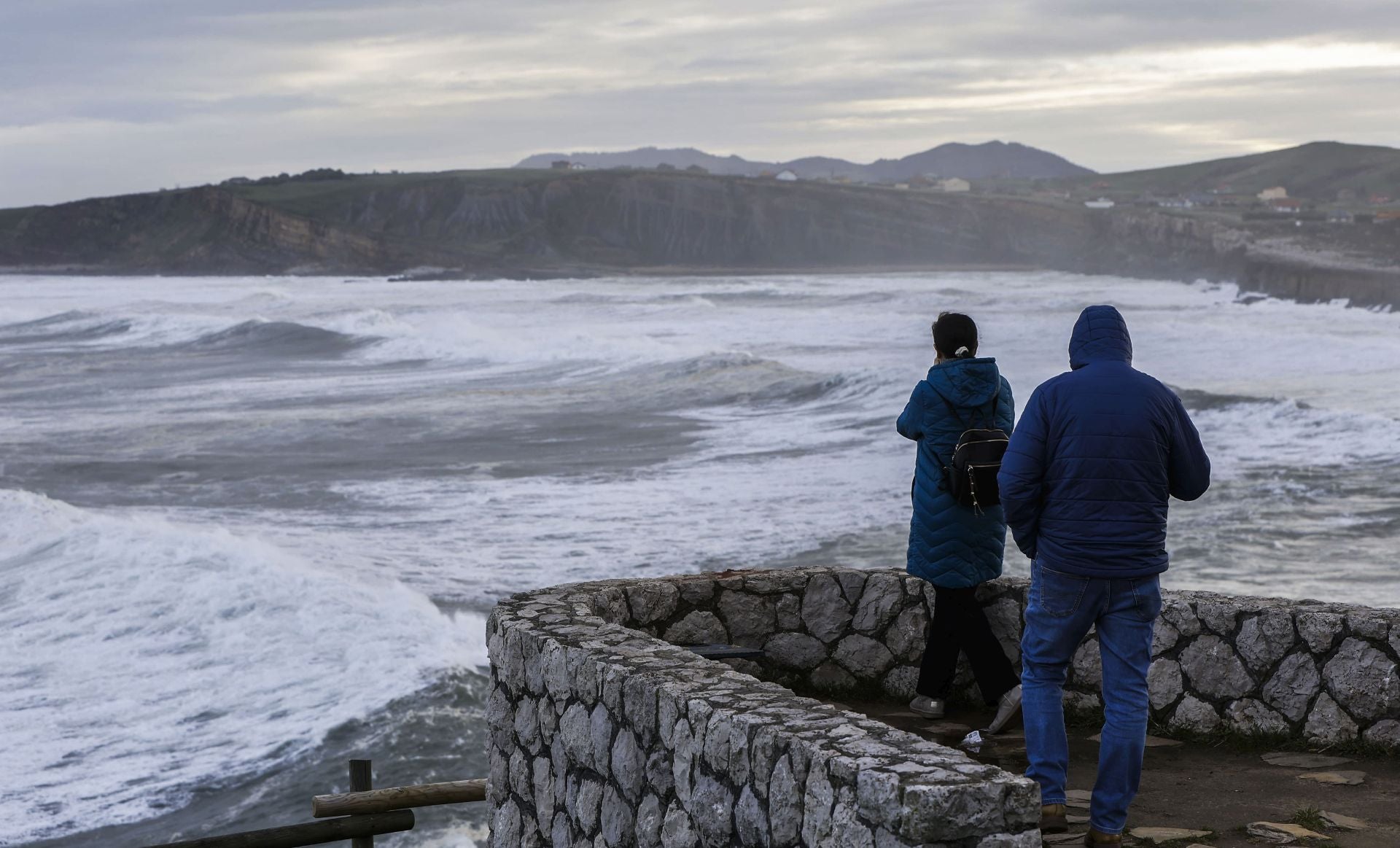 Dos personas contemplan el mar en Suances.