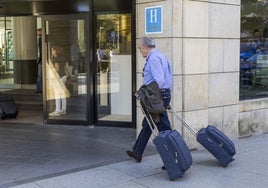 Un turista accede con sus dos maletas al hotel Bahía, en el centro de Santander.