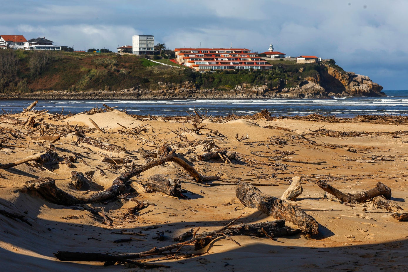 Multitud de troncos, palos y remontes en la playa de La Concha, en Suances.