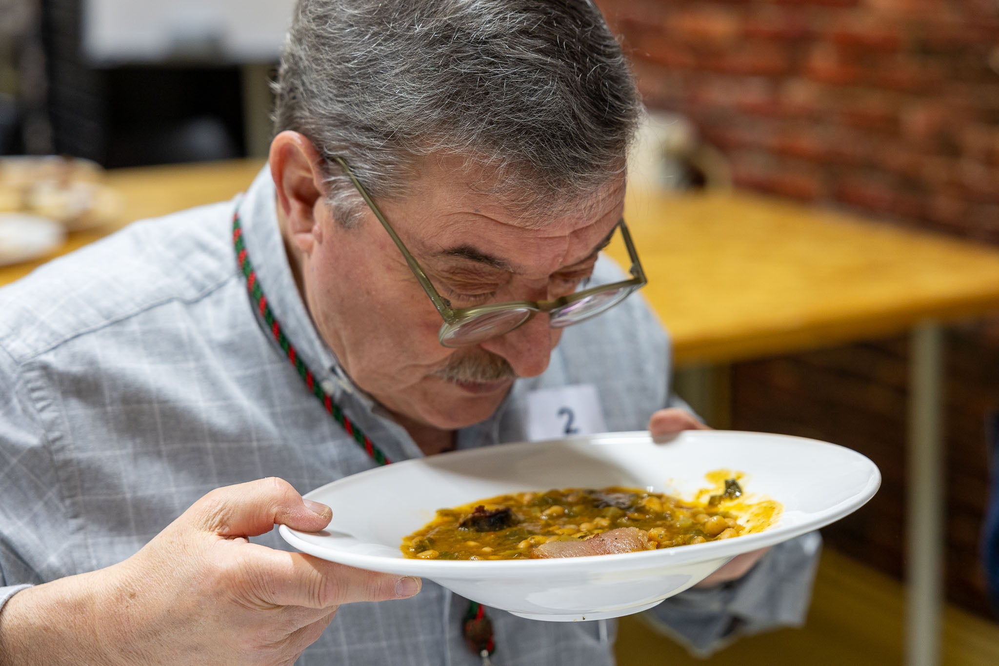 Manuel Rodríguez, cofrade de los Cocidos, analiza los aromas de uno de los platos presentados.