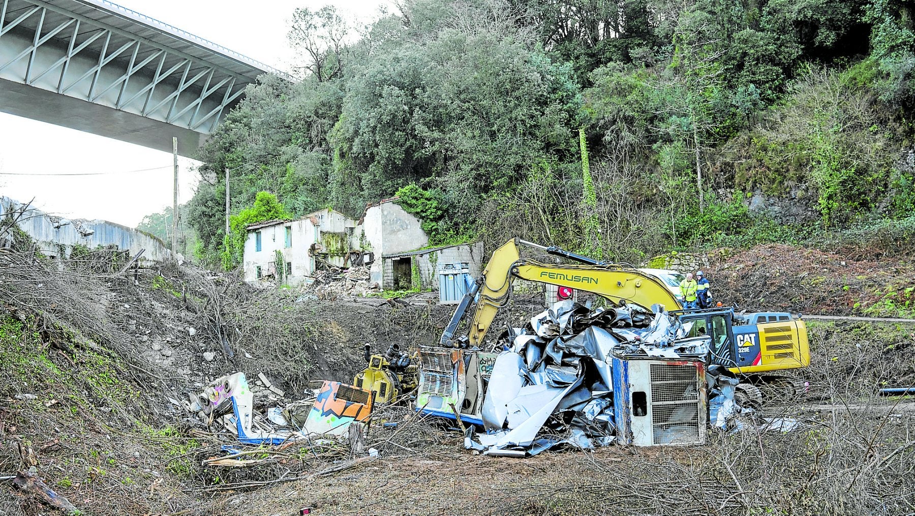 Una maquina retira los últimos restos del tren siniestrado y del material que transportaba.