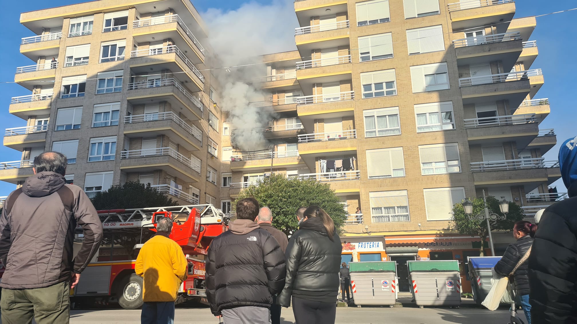 Vecinos siguen la evolución del incendio, originado en un piso de la cuarta planta del número 30 de la Avenida del Besaya.