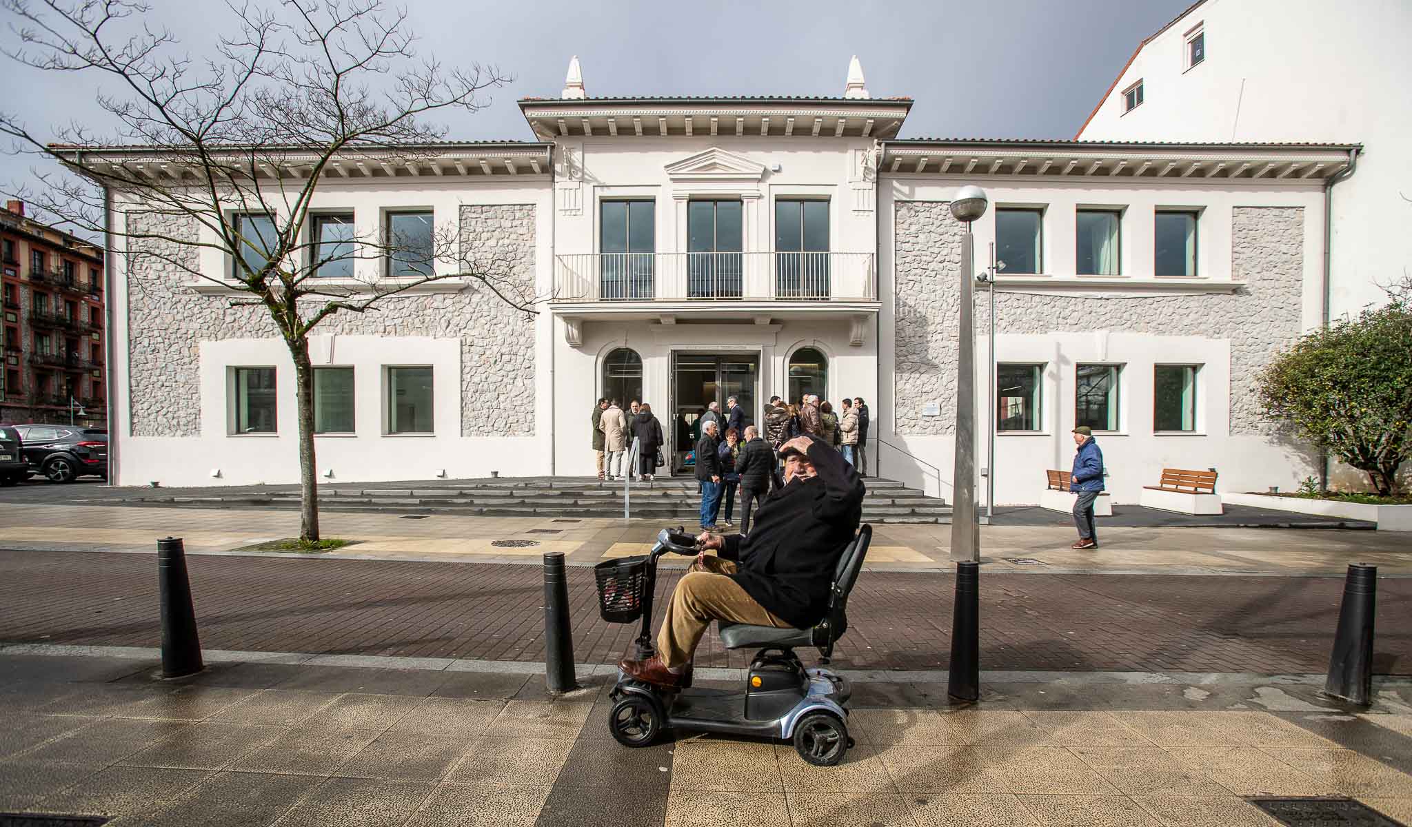 Un vecino circula por la plaza de La Llama, frente a la nueva sede del Consistorio, este viernes, en Torrelavega. 