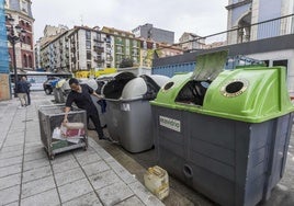 Un hombre hace uso de los contenedores localizados en el entorno del Mercado de Puertochico.