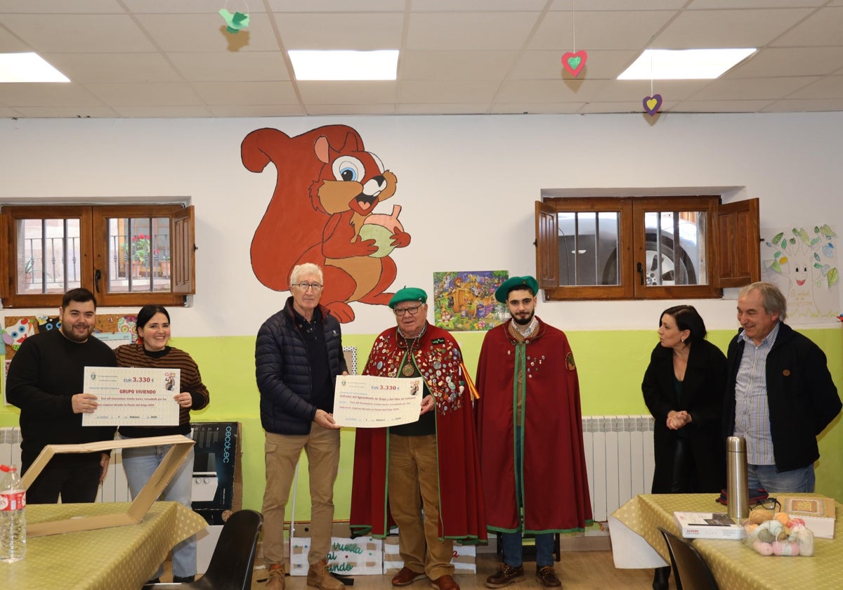 Entrega de los cheques a la cofradía del orujo y al grupo Viviendo