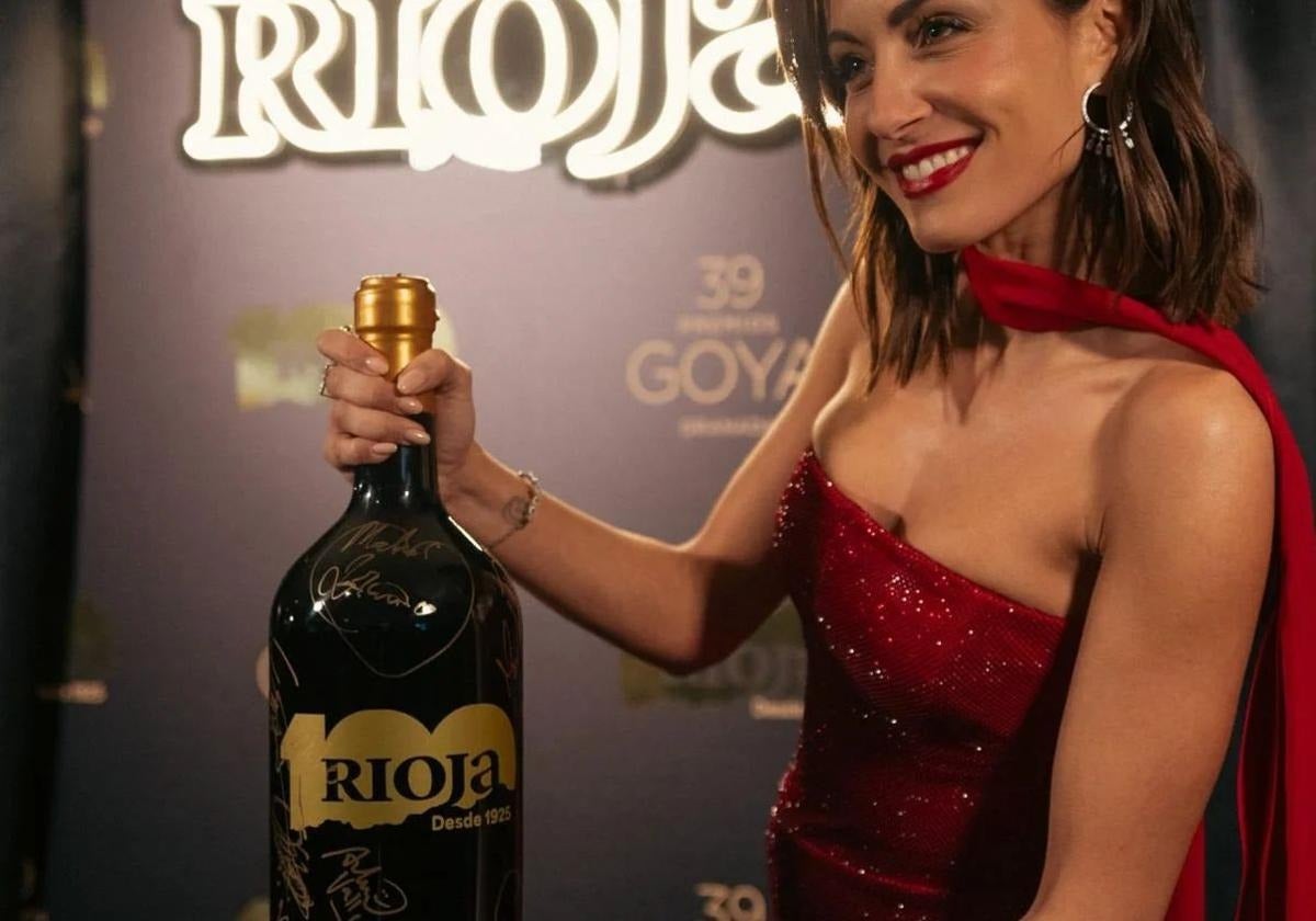 La actriz Hiba Abouk posando con una de las botellas que desaparecieron.