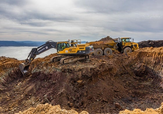 Una pala excavadora retira tierra para proceder a la cimentación del tercer aerogenerador del proyecto, en Campoo de Yuso. De fondo, el pantano del Ebro.