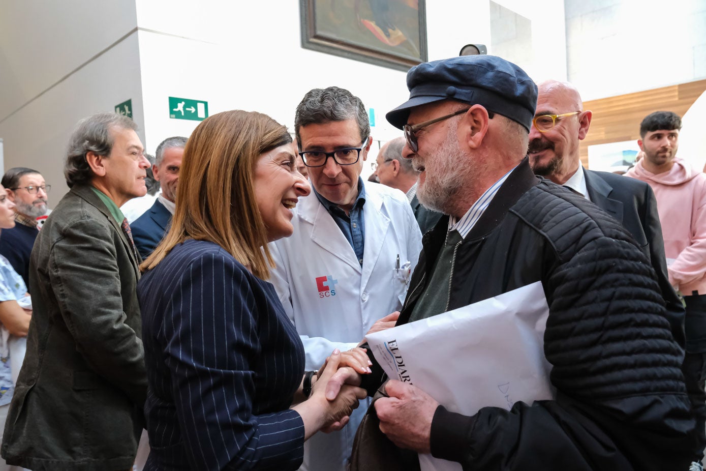 Sáenz de Buruaga saluda a Tomás Calvo, el primer paciente trasplantado en 1975. A su lado, el gerente de Valdecilla, Félix Rubial, y el consejero de Salud, César Pascual, al término del acto.