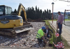 Un operario realiza las labores de construcción de las nuevas pistas de petanca en Zurita, junto al alcalde y al concejal del área.