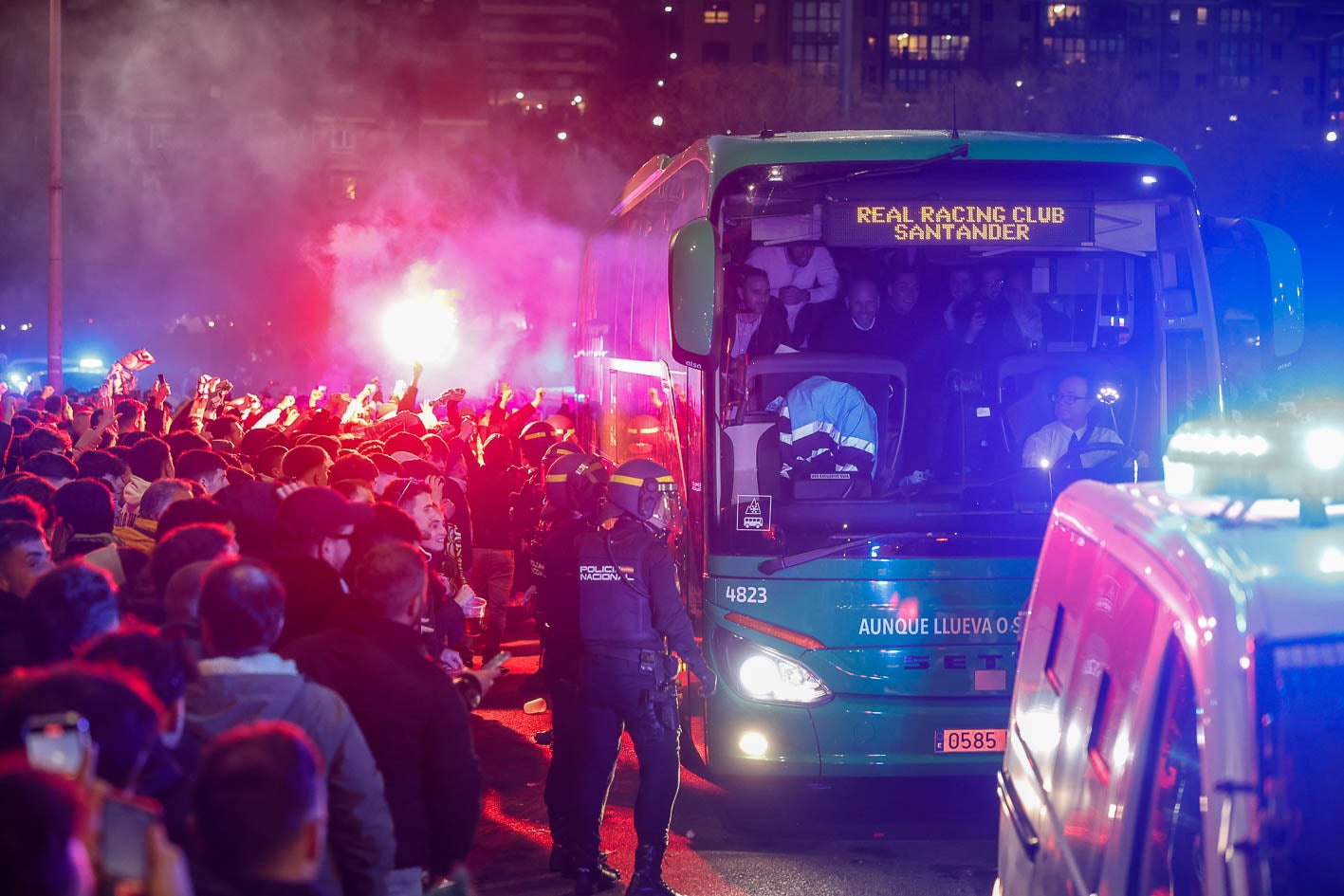 La policía y aficionados abren paso al autobús del Racing.