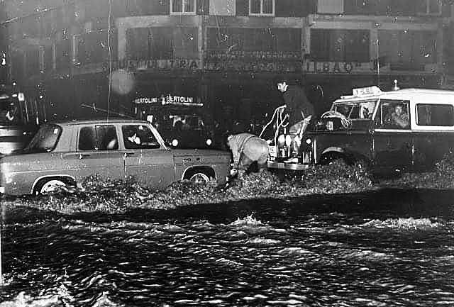 Coches circulan por un inundado cruce de Cuatro Caminos.