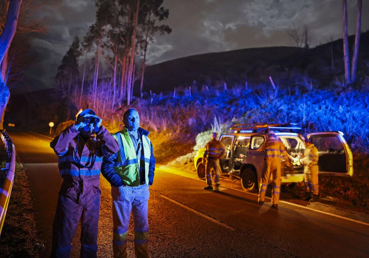 Operarios del servicio de extinción, en la noche del martes al miércoles en la carretera de la collada de Carmona.