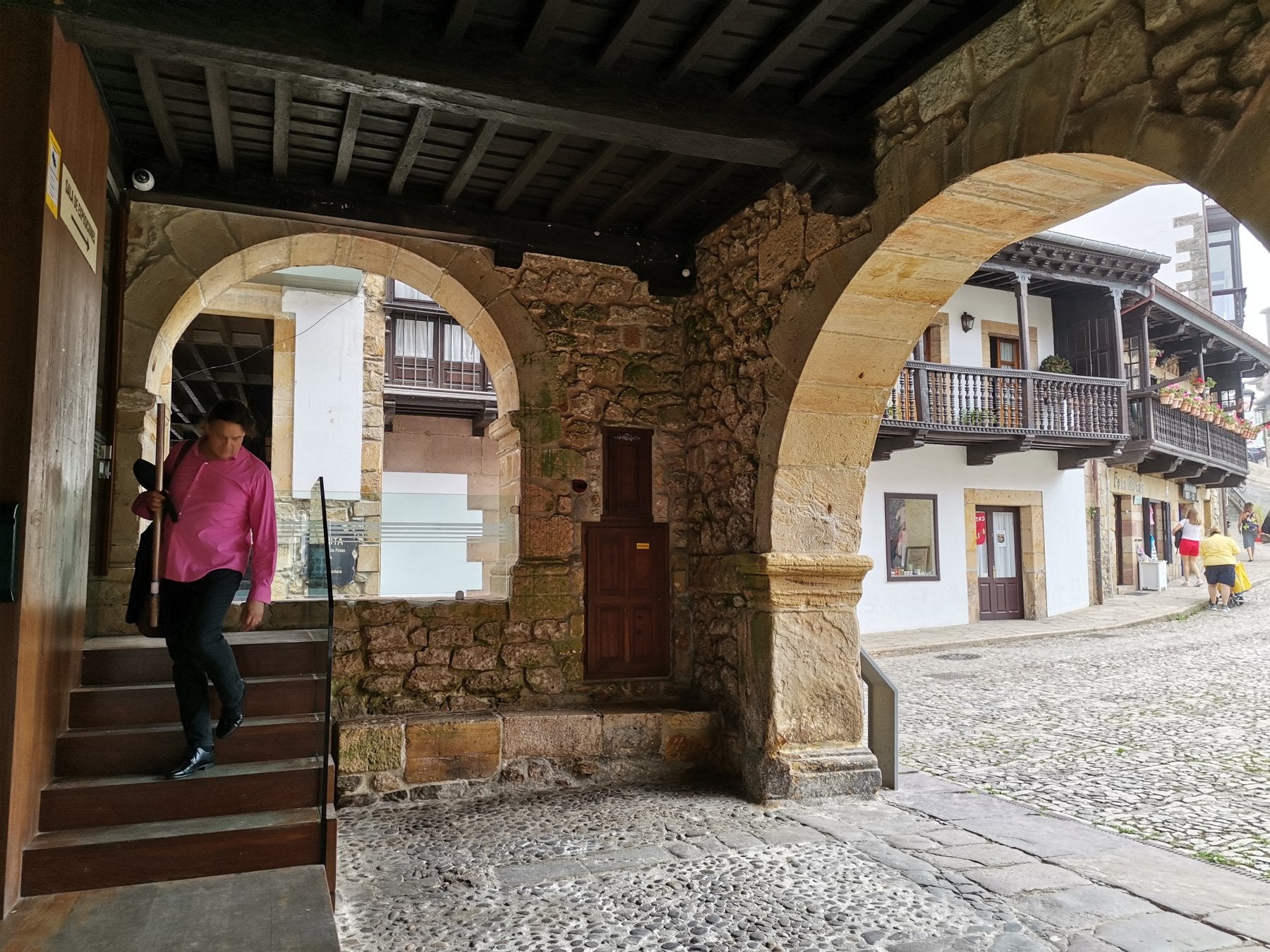 Una persona baja las escaleras que dan a los soportales del antiguo ayuntamiento.