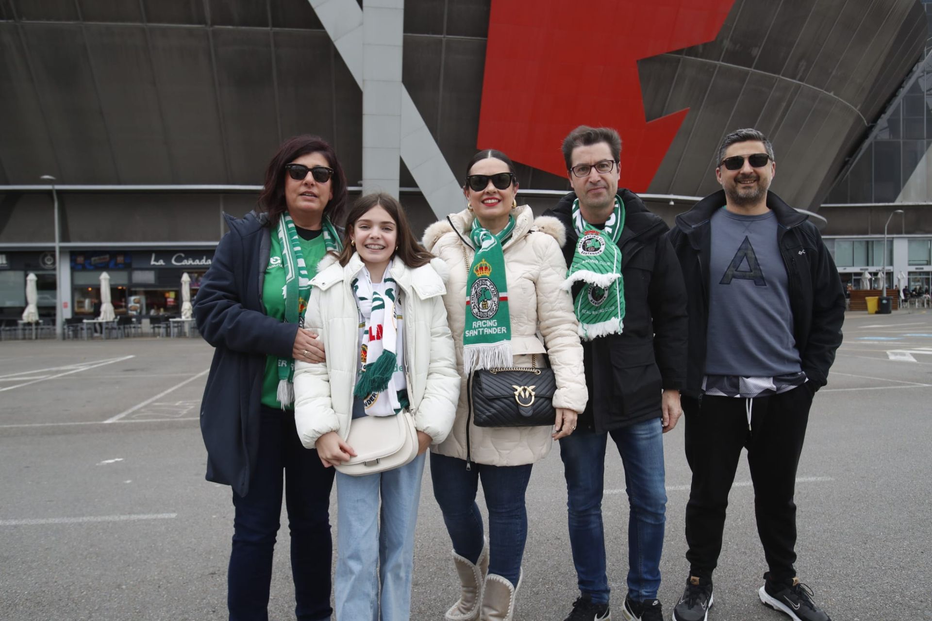 Cinco aficionados posan a las afueras del estadio gijonés.