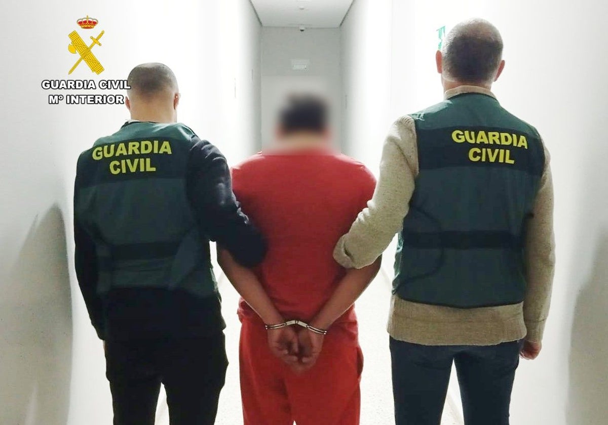 Dos guardias civiles trasladan al detenido a sus dependencias.