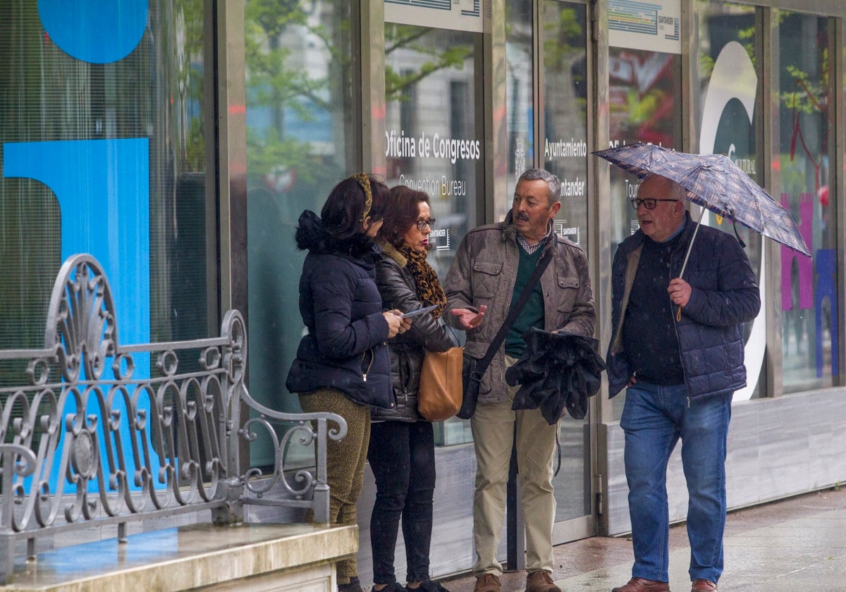 Turistas bajo la lluvia en Santander, en una imagen de archivo.
