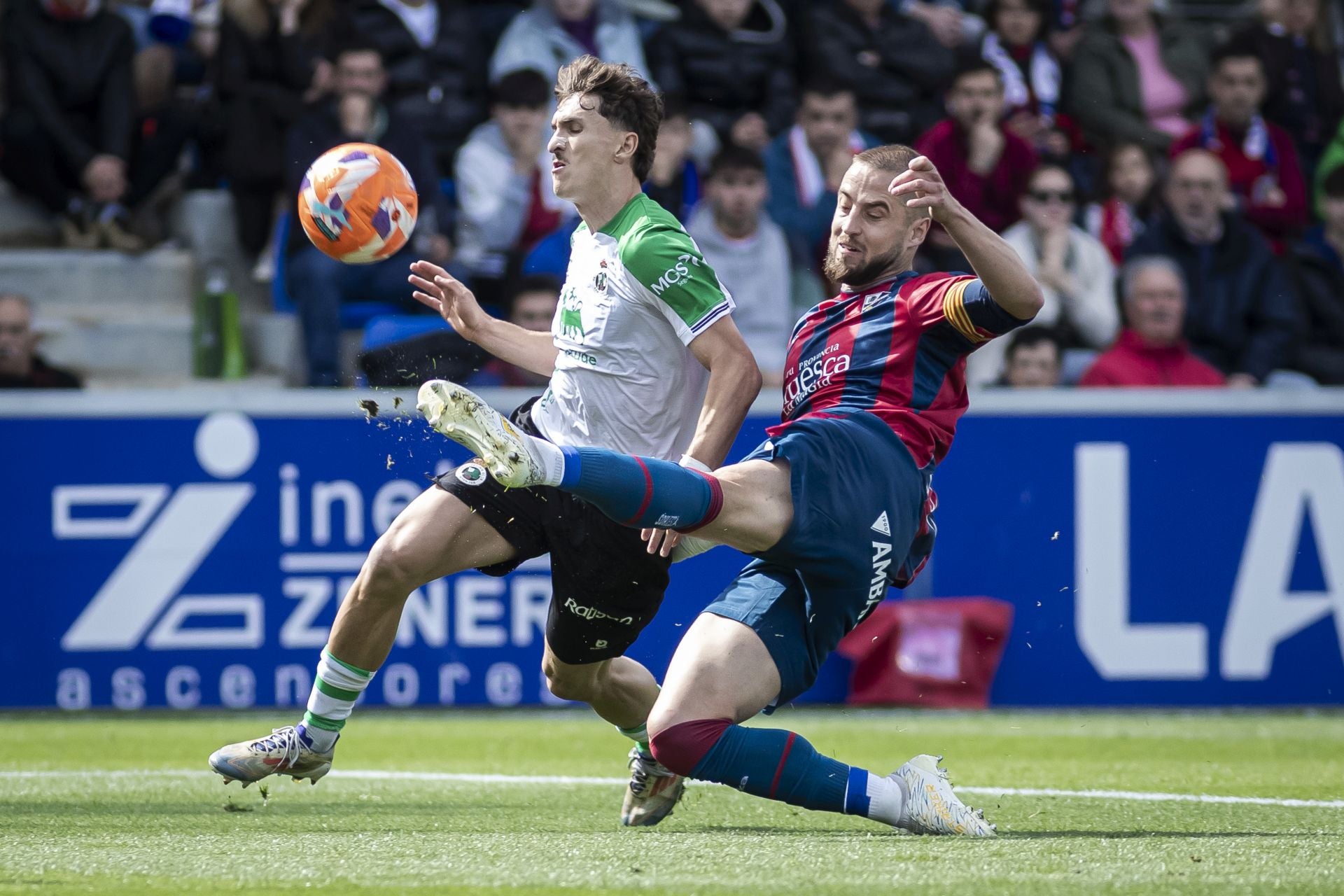 Jorge Pulido, del Huesca, que terminó expulsado, trata de robar el balón a Pablo Rodríguez