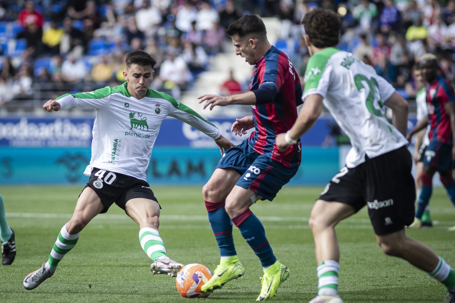 El canterano Mario García busca robar la pelota a un jugador del Huesca