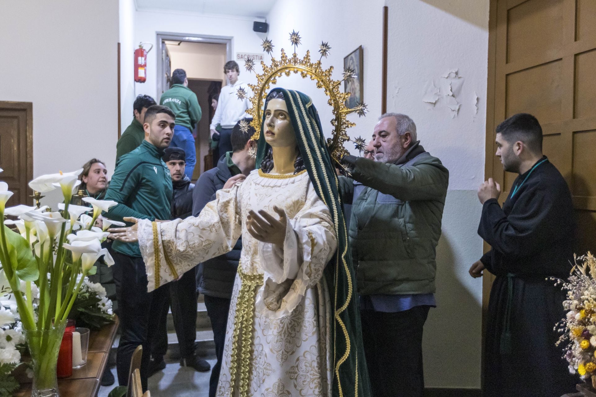 El manto de la virgen mide 15 metros,es de terciopelo verde esperanza y lleva bordados decorativos