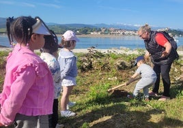 Uno de los escolares cavando el terreno para plantar un árbol.