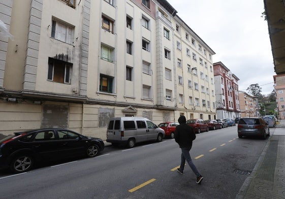 Un vecino cruza la calle frente al número 9 de la calle Marqueses de Valdecilla y Pelayo, en Torrelavega.