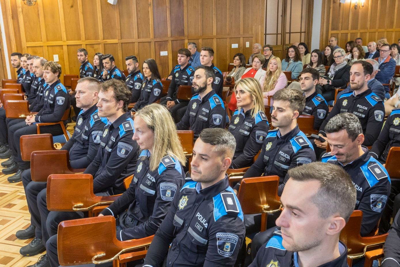 Los 29 nuevos agentes de la Policía Local de Santander, en un momento del acto de bienvenida. Justo detrás, sus familiares. 