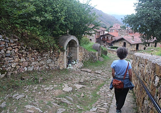 Una mujer baja por el acceso antiguo y original a Los Pinos en San Sebastián de Garabandal.