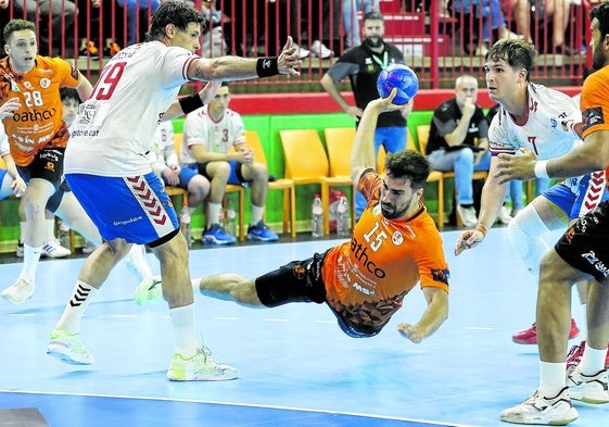 Juanjo Fernández, lateral del Bathco, dispara mientras esquiva a Antonio García, del Granollers