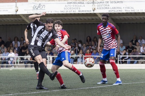 Nacho Martínez, del Escobedo, golpea la pelota ante dos rivales del Llanera.