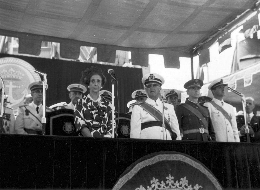 De izquierda a derecha, la mujer del jefe de Estado, Carmen Polo; el jefe de Estado en ese momento, Francisco Franco; el entonces Príncipe Juan Carlos de Borbón, en la tribuna, durante el desfile de la Semana Naval en Santander el día 6 de julio.