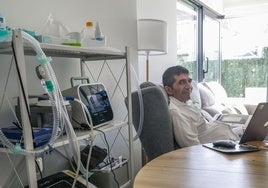 David Rey, en el salón de su casa de Santander, rodeado de las distintas máquinas que requiere por los devastadores efectos de la ELA.