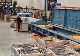 Un trabajador de la empresa junto a los cables de acero fabricados.