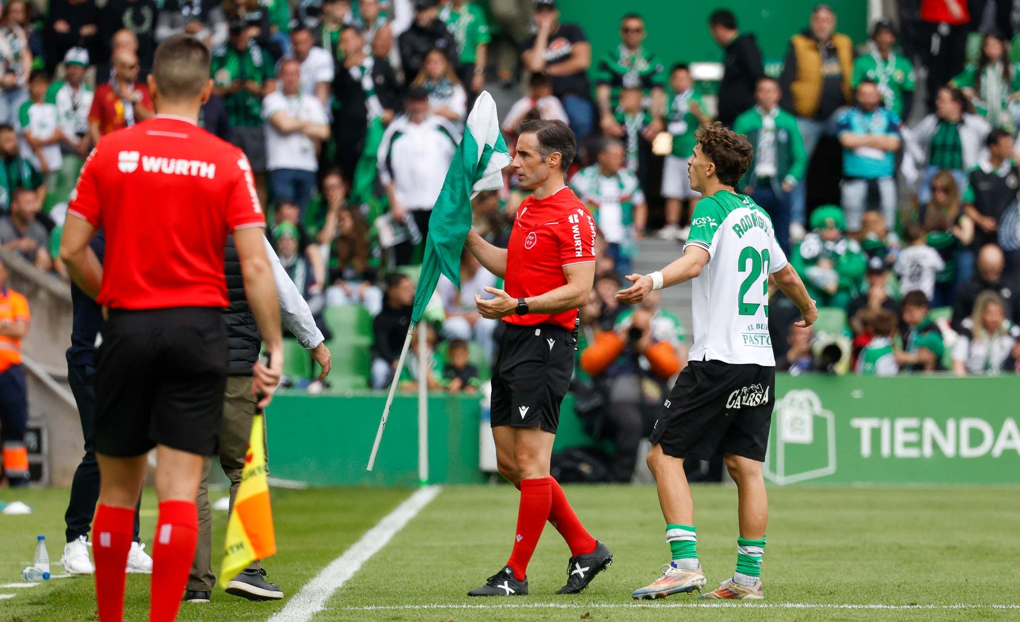 González Esteban recoge una bandera del Racing lanzada al terreno de juego.