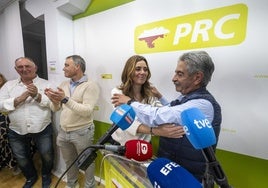 Revilla se abraza con Paula Fernández, con el logotipo actual del PRC a sus espaldas, tras conocer el resultado de las primarias.