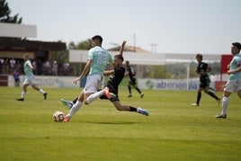 Espinosa, del Escobedo, lleva la pelota ante un rival del Barbastro.