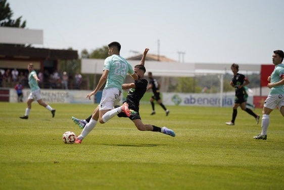 Espinosa, del Escobedo, lleva la pelota ante un rival del Barbastro.